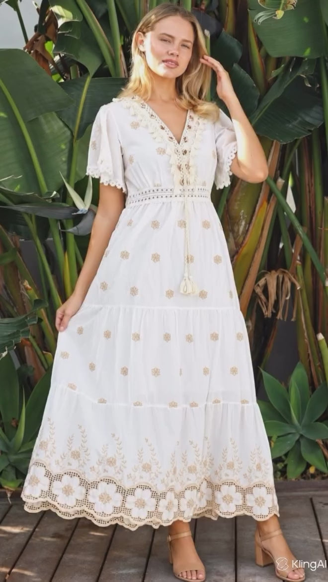 Model in motion wearing the Honeyed Garden white cotton boho dress with ivory beige floral embroidery and lace detailing from Bohemian Love Runway.