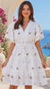Model in motion wearing the Taylah white embroidered cotton mini dress by Salty Palm with broderie anglaise, floral embroidery and crochet lace waist | Bohemian Love Runway 