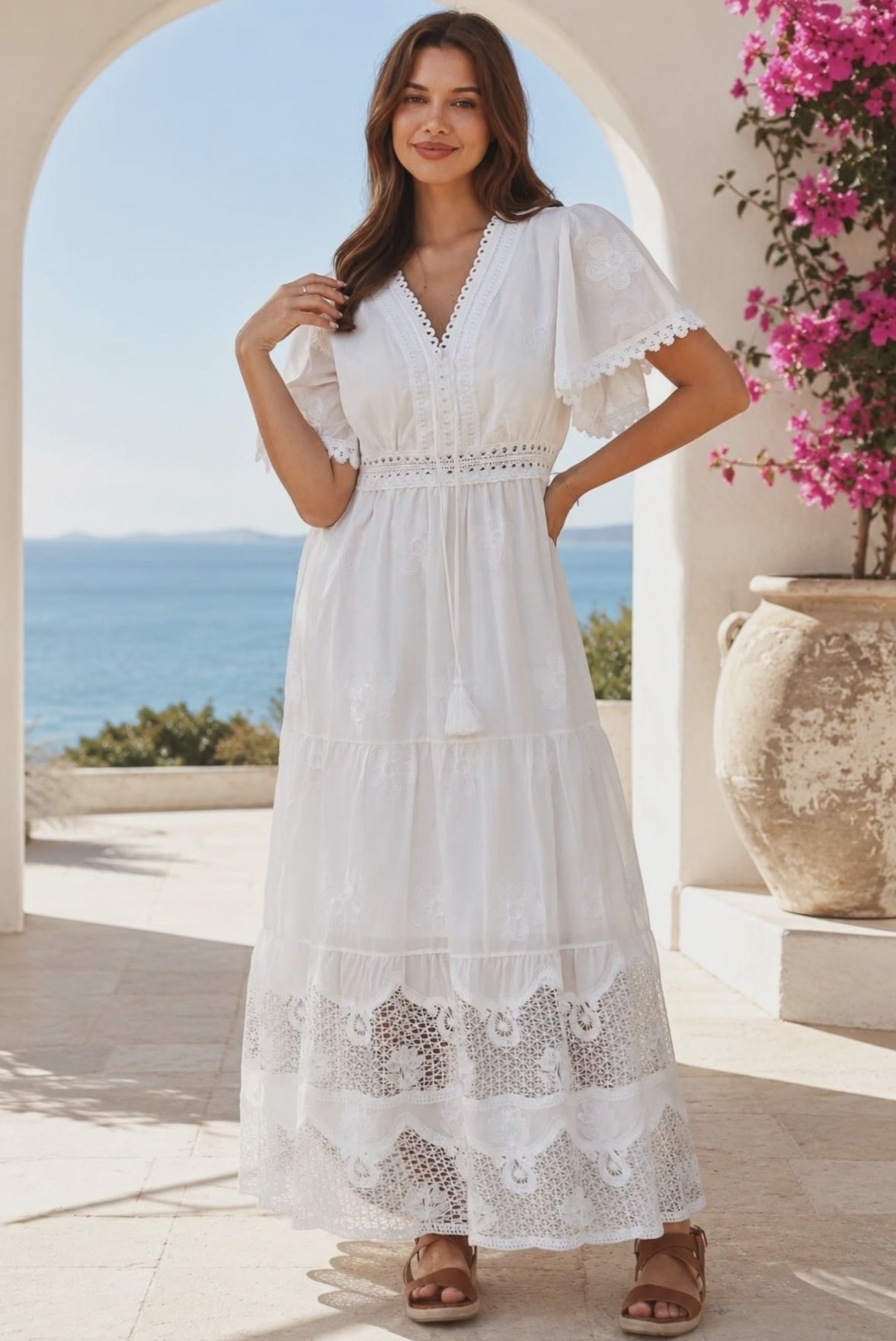 Model in motion wearing the Willow white embroidered cotton maxi dress with openwork lace and tassel ties by Salty Palm at Bohemian Love Runway
