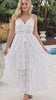 Model in motion wearing the Olivia white embroidered cotton maxi dress with lace waist, tassel V-neck, adjustable straps and tiered skirt | Bohemian Love Runway