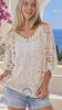 Model in motion wearing the Lucia cream 100% cotton crochet boho top with V-neck front and back, oversized batwing sleeves and openwork design | Bohemian Love Runway