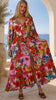 Model in motion wearing the Scarlet floral long sleeve boho maxi dress with V-neck, buttons, elastic waist and lace detail at Bohemian Love Runway