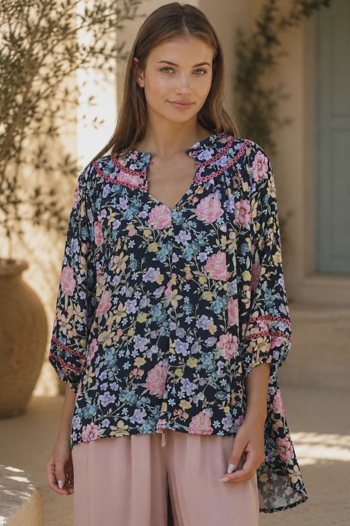 Model in motion wearing the Primrose navy floral boho blouse in 100% rayon by Charlotte The Label | Bohemian Love Runway