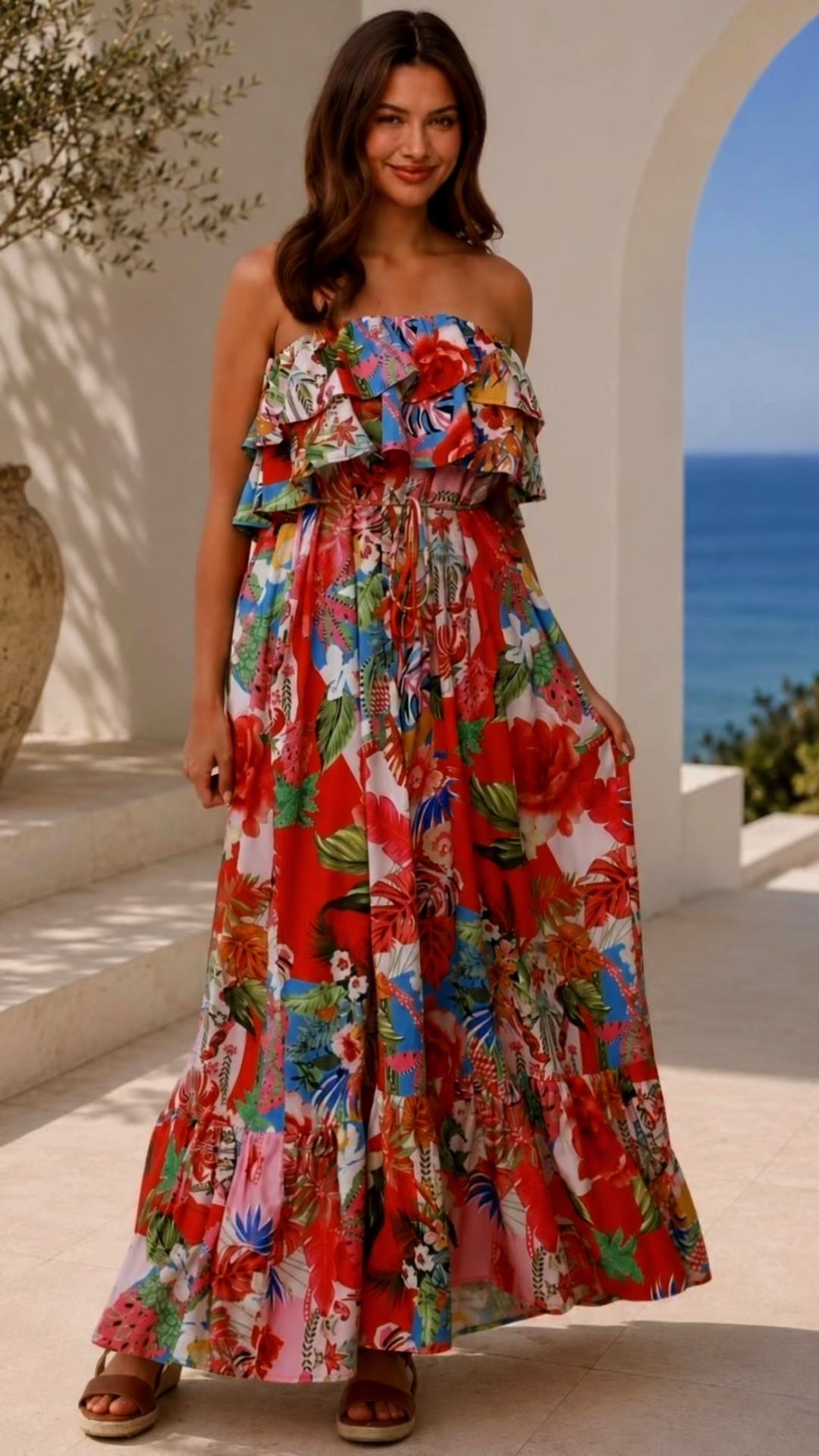 Model wearing the Scarlet floral strapless maxi dress by Dreamcatcher with double frill, waist tie and oversized frill hem