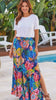 Model in motion wearing the Dreamcatcher Wild Tropic blue boho maxi skirt with tropical floral print, side splits, tassel tie and flowing tiered hem at Bohemian Love Runway 