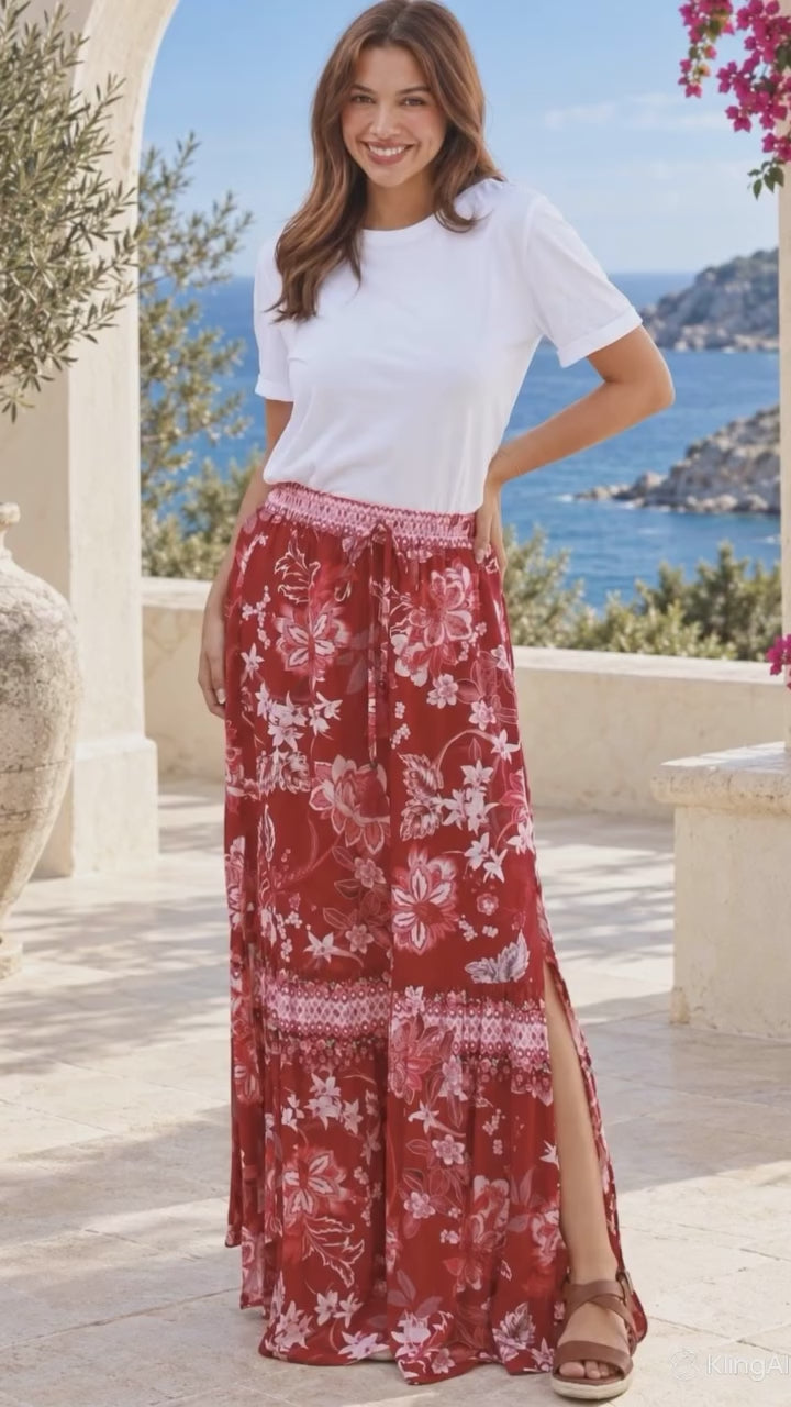 Model in motion wearing the Claudette floral boho maxi skirt in ruby red, blush pink and ivory with border print, elastic waist and side splits at Bohemian Love Runway.