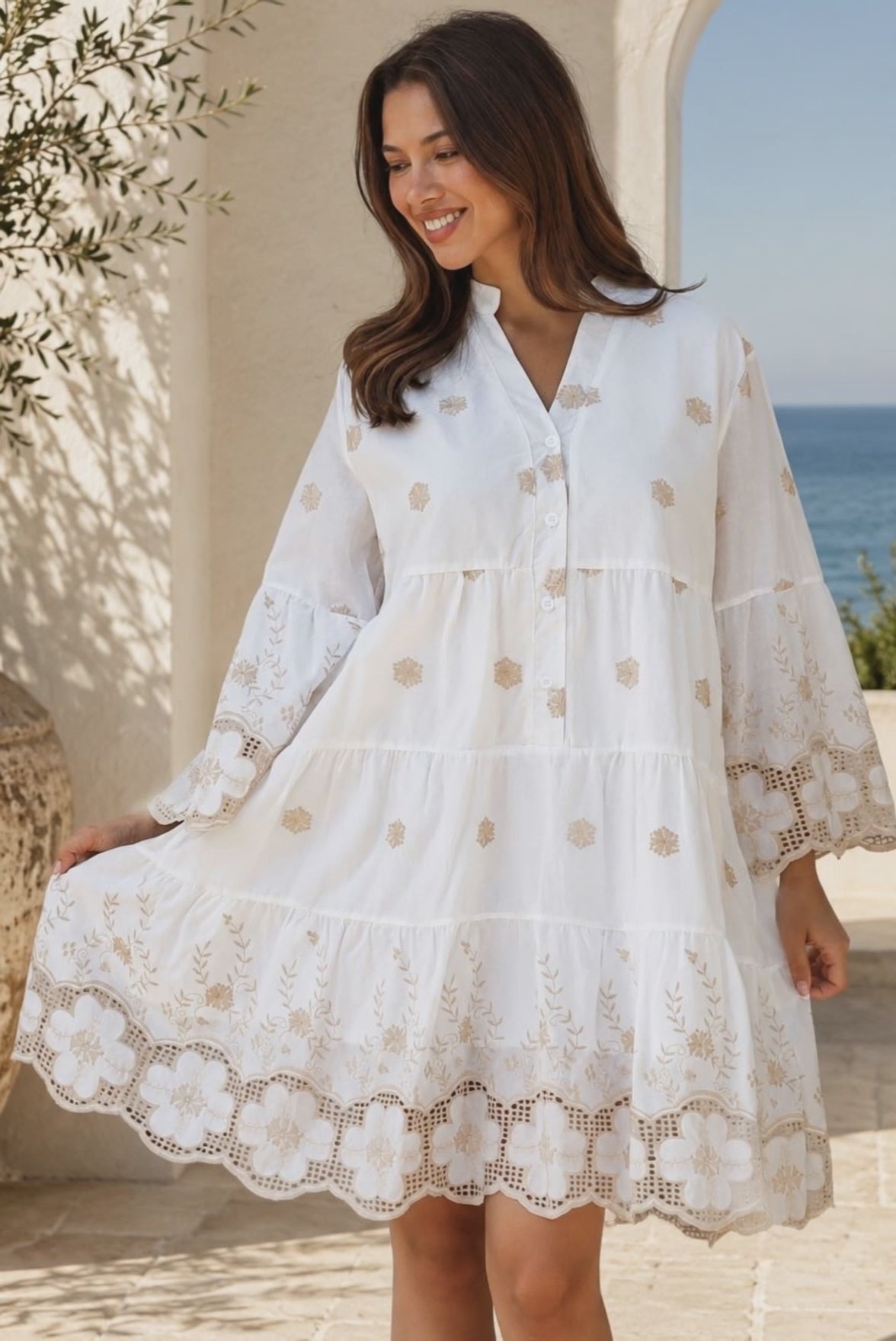 Model wearing the Honeyed Garden white cotton embroidered mini dress with floral cutwork hem and sleeves at Bohemian Love Runway