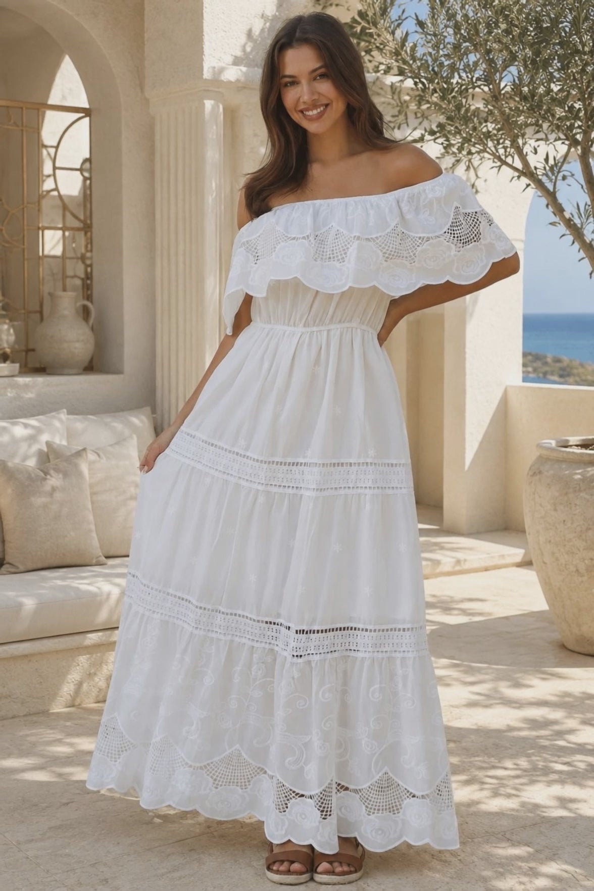 Model in motion wearing the Rose white embroidered cotton maxi dress with off-shoulder floral lace, tiered skirt and scalloped rose hem