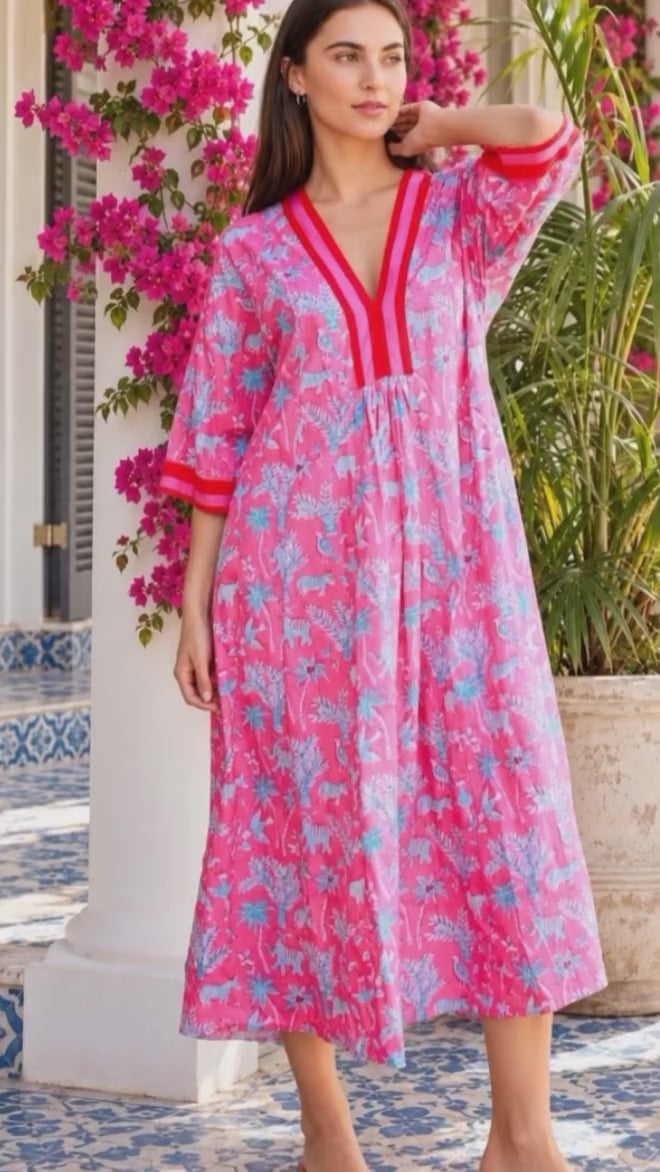 Model in motion wearing the Sanctuary Pluto Pink cotton boho midi dress with turquoise wildlife block print, V-neckline and contrast trim | Bohemian Love Runway