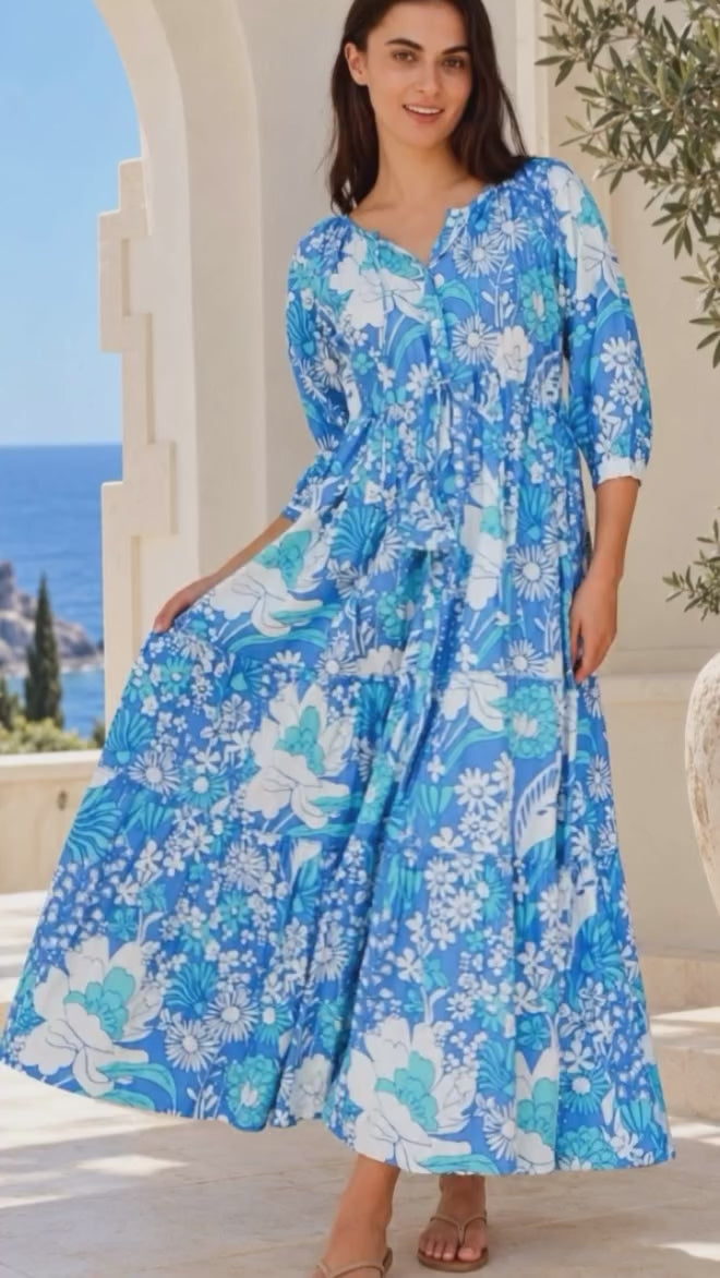 Model in motion wearing the Emerson Cotton Maxi Dress Rory Blue with vintage blue floral print, button front, tassel drawstring waist and tiered skirt | Bohemian Love Runway