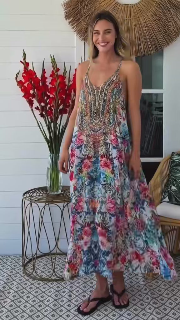 “Woman twirling in a white boho midi dress with rhinestone detailing and tropical floral print — Wanderlust in Bloom Midi Dress by Peacock Feather, Bohemian Love Runway.”