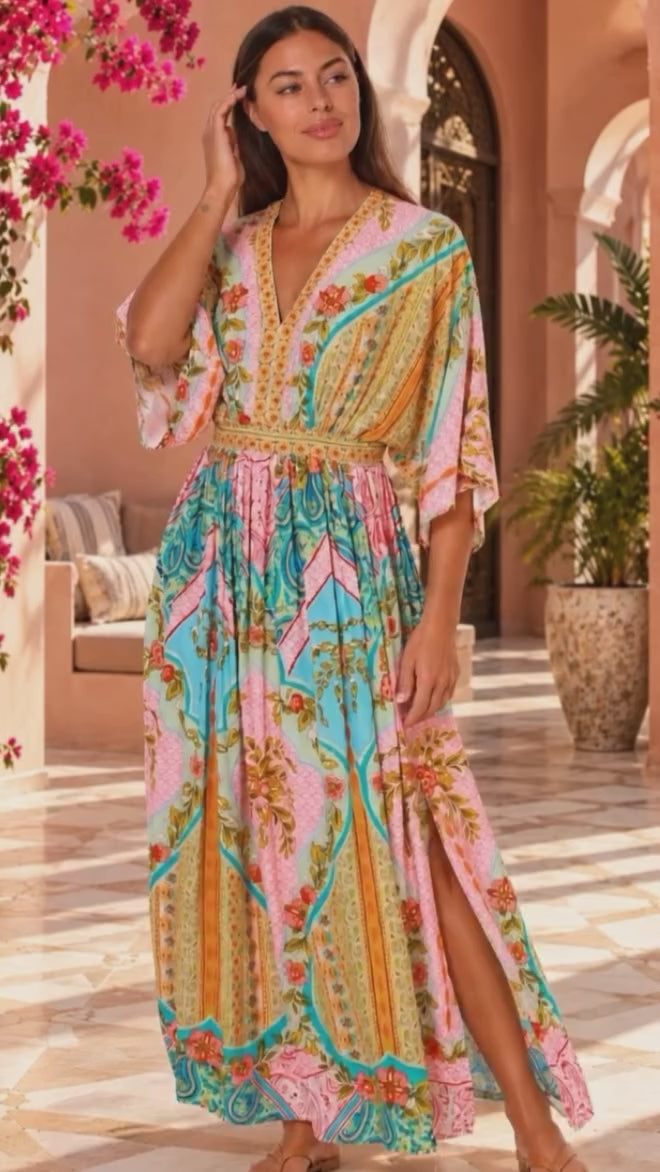 Model in motion wearing the Amara pink turquoise floral paisley maxi dress by Dream Catcher with V-neck, kimono sleeves and border print | Bohemian Love Runway