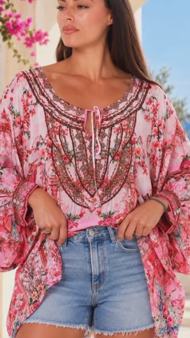 Model in motion wearing the Clara Embellished Tunic Blouse Rose by Peacock Feather with rhinestone neckline floral viscose crepe one size | Bohemian Love Runway