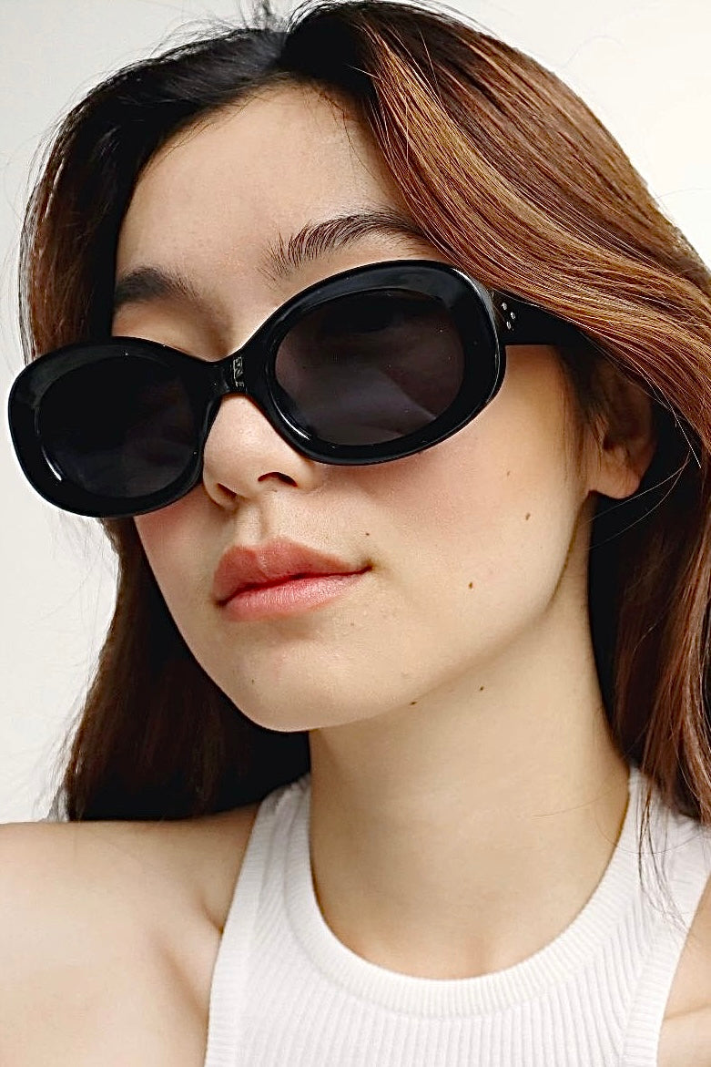 Woman in black oversized sunglasses with soft waves and white high neck top - chic boho summer style.