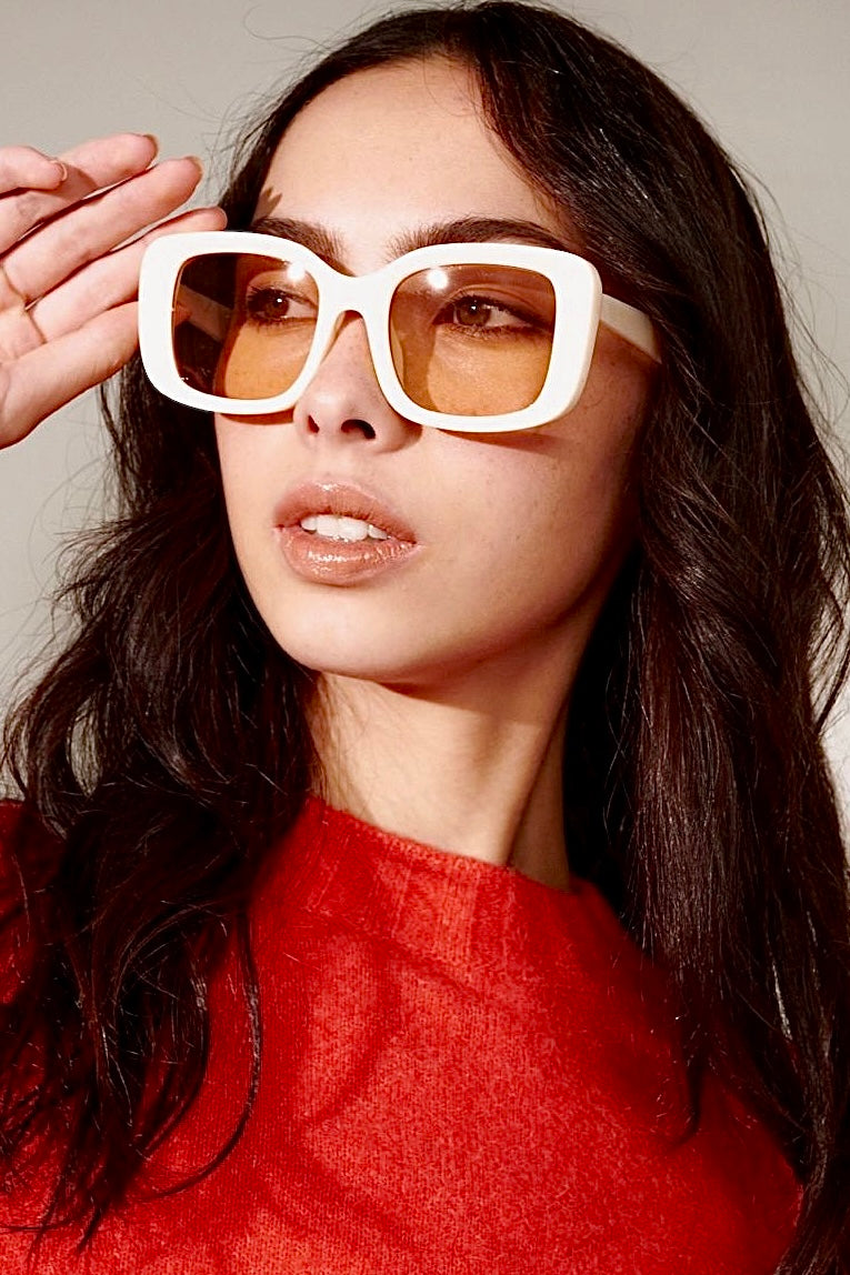 Woman in a white retro square sunglasses and red top with soft waves - bold boho fashion statement Australia.