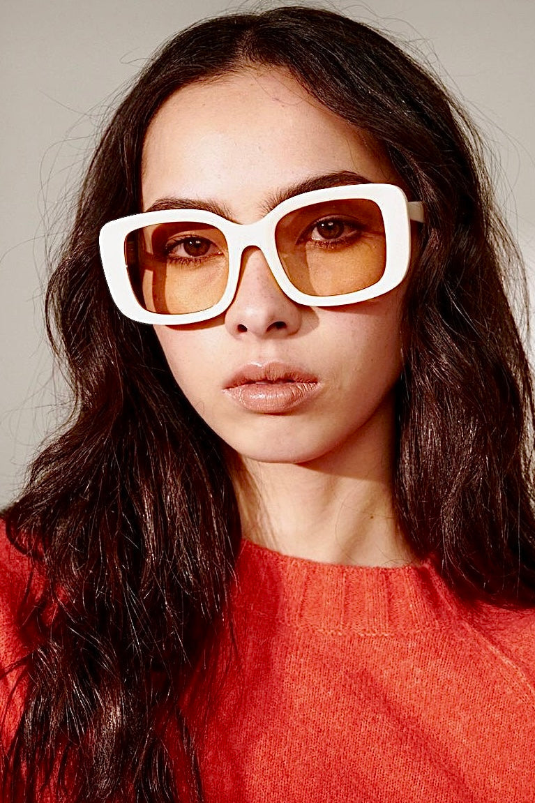 Woman in a white retro square sunglasses and red top with soft waves - bold boho fashion statement Australia.
